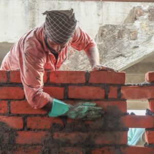 a man is working on a brick wall