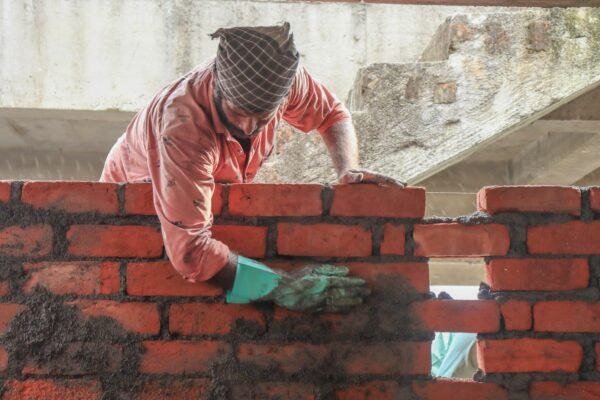 a man is working on a brick wall